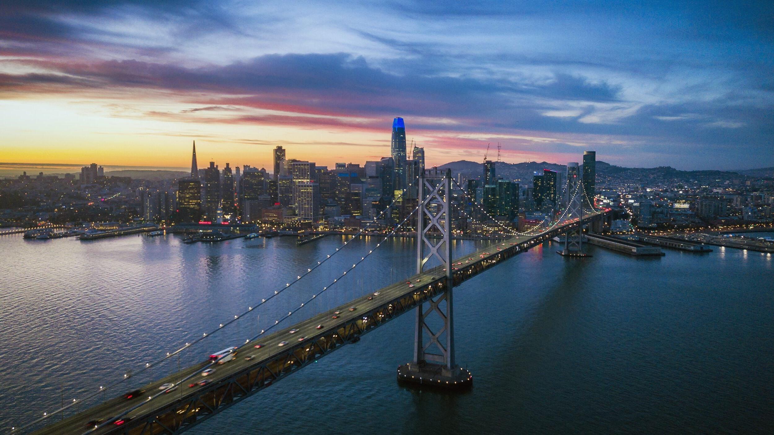 San Francisco skyline with bridge at sunset.